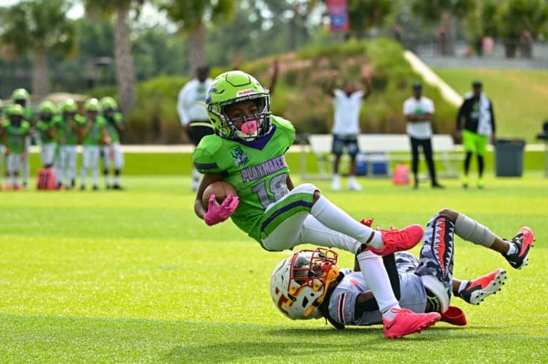 A ball carrier being tackled during a youth football game